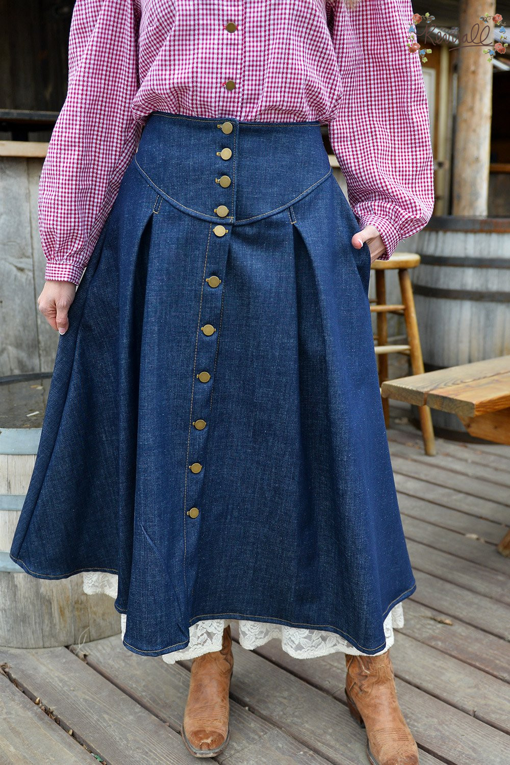 a woman stands in front of an old saloon in Montana wearing a red and white gingham and denim prairie outfit