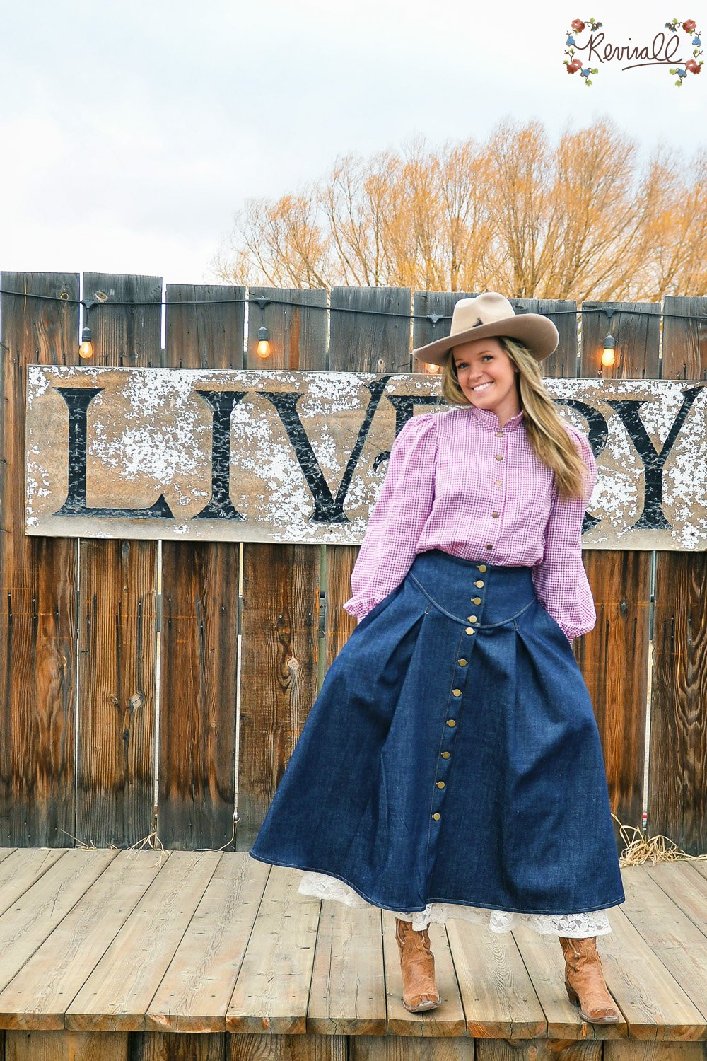 a woman stands in front of an old saloon in Montana wearing a red and white gingham and denim prairie outfit